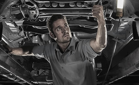 Image of a mechanic working beneath a truck.