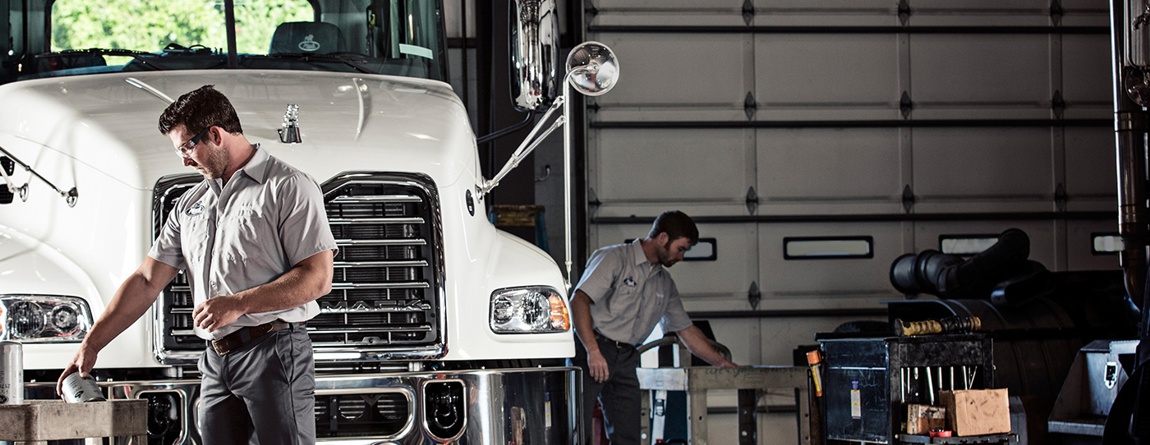 Image of 2 people in a garage working.