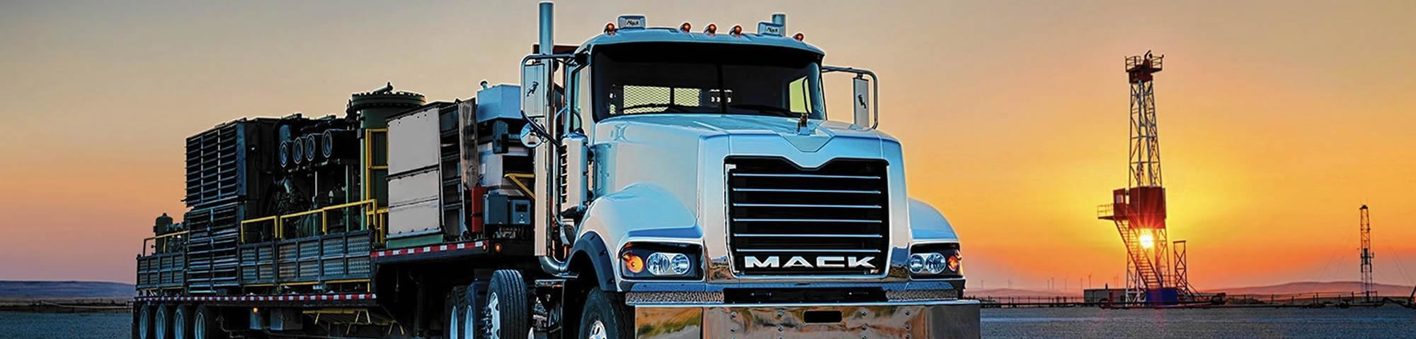 Image of a Mack truck in front of a sunset.